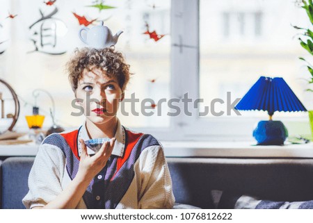 girl drinks tea with a teapot on her head