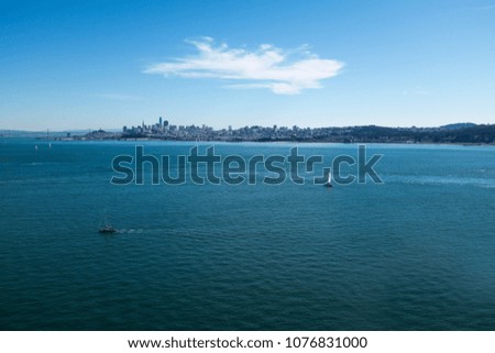 Sailboat in San Francisco bay below Golden Gate bridge with the panorama of city in distance 