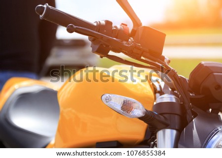Close-up view of motorcycle handle bar with switches and mirror. Motorcycle - parts shredder, lights, steering wheel and gas tank close-up. on a sunny day