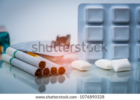 Nicotine chewing gum in blister pack near pile of cigarette. Quit smoking or smoking cessation and lung cancer concept. 31 May : World no tobacco day. Royalty-Free Stock Photo #1076890328