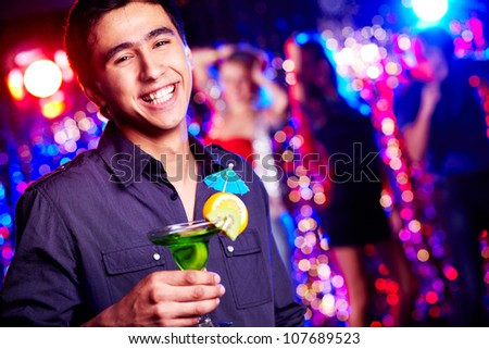 Image of happy guy holding cocktail at party