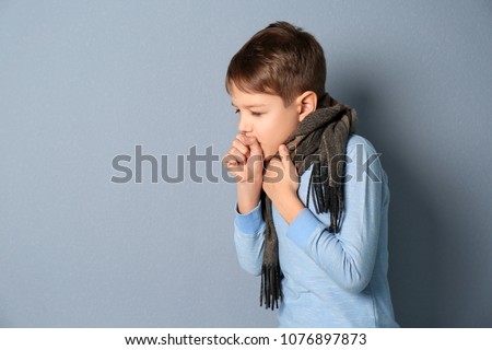 Little boy coughing on grey background Royalty-Free Stock Photo #1076897873