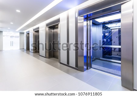 Modern steel elevator doors opened cabins in a business lobby or Hotel, Store, interior, office,perspective wide angle. Four elevators in hotel lobby. Royalty-Free Stock Photo #1076911805