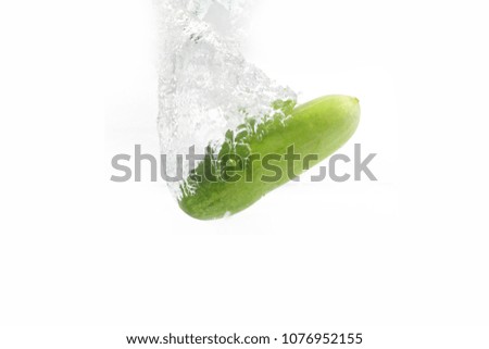fresh cucumber and water splash on white background