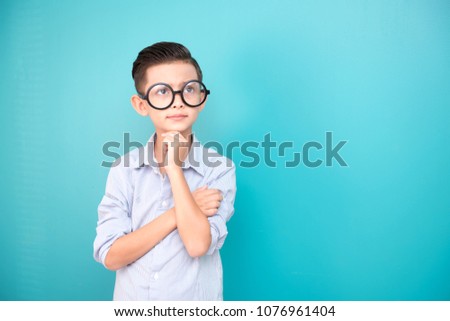 Nerdy young boy isolated in blue. Handsome early teenage boy portrait. confident looking pose.