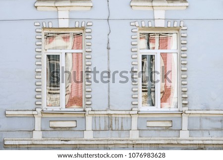 Reflections in the windows of an old house. Fragment of the facade. The picture was taken in Russia, in the city of Orenburg. 04/07/2018