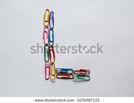 Alphabet L made from color paper clips on white background. Joyfully education. Royalty-Free Stock Photo #1076987123