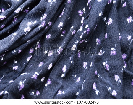 Cotton fabric is blue with small flowers. With soft folds. Background, texture.