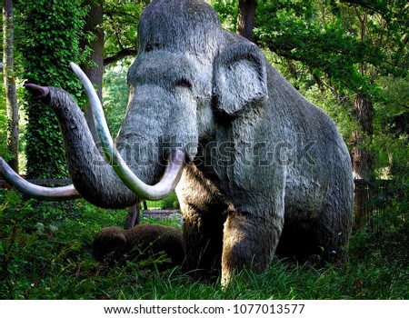 An lifelike artificial big mammoth, caught in the green jungle