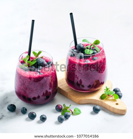 Freshly squeezed blueberry juice on the table. a healthy summer drink in two glasses.