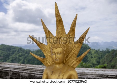 Small Golden Buddha Statue with Blurred Landscape Background at Tiger Cave Temple (Wat Tham Suea), Thailand
