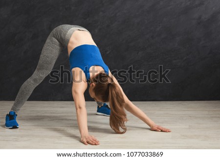 Fitness woman stretching her body training at gym. Young slim girl makes aerobics exercise, copy space