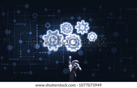 Close of businessman hand pointing with finger at gear mechanism