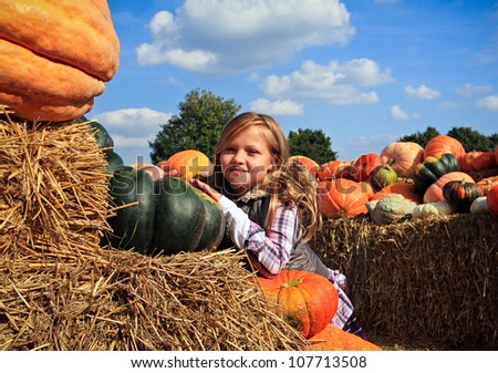 Cute little girls in a pumpkin patch Royalty-Free Stock Photo #107713508