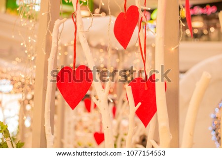 Valentine's red hearts hanging on the blurred golden bokeh background. Romantic decoration for Valentines Day. Retro or vintage style