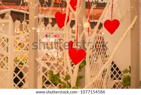 Valentine's red hearts hanging on the blurred golden bokeh background. Romantic decoration for Valentines Day. Retro or vintage style
