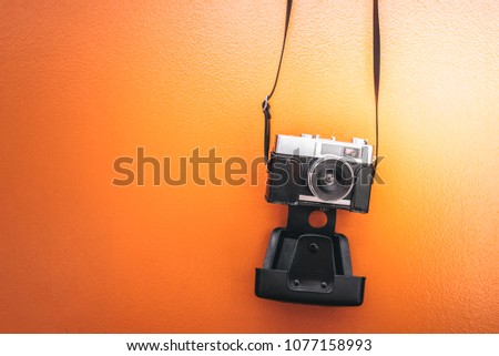 Vintage camera isolated at orange wall