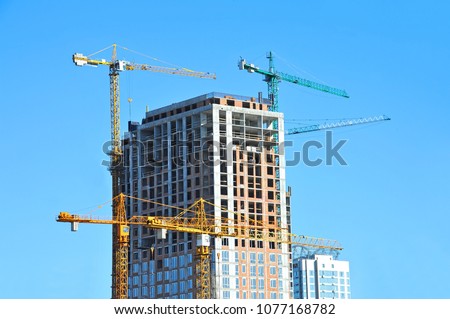 Crane and building under construction against blue sky Royalty-Free Stock Photo #1077168782