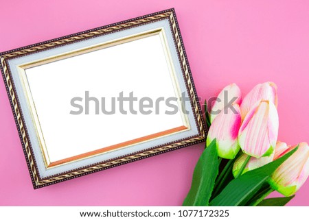 Beautiful of yellow tulip flower and photo frame border, with flat lay on the pink background, top view, copy space, mother day and holiday concept.