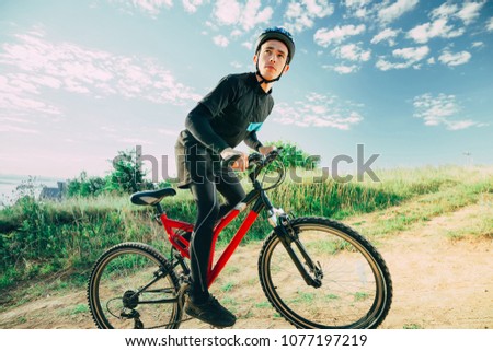 Man Cyclist with bike on sunrise at sunny summer