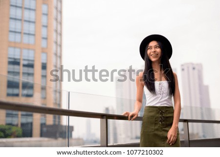 Portrait of young beautiful Asian woman exploring the city of Bangkok, Thailand