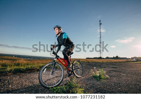 Man Cyclist with bike on sunrise at sunny summer