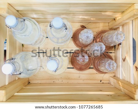 Many bottle of water and glass place in wooden box with copy space for your text and design. Concept be used for modern design in vintage home and used for background. Blur picture.