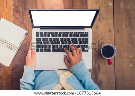 Beautiful girl used Laptop and coffee cup in girl's hands sitting on a wooden floor