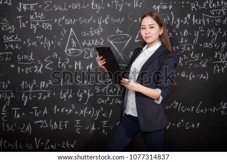 a beautiful Asian student stands near a complex example with a folder for documents