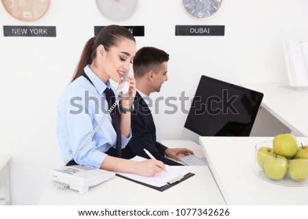 Busy receptionists at workplace in hotel Royalty-Free Stock Photo #1077342626