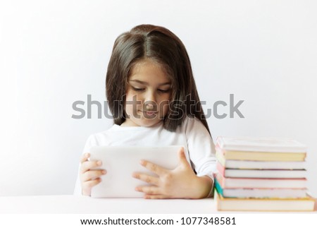 leisure, childhood, technology and people concept - cute little girl child with gadget and books