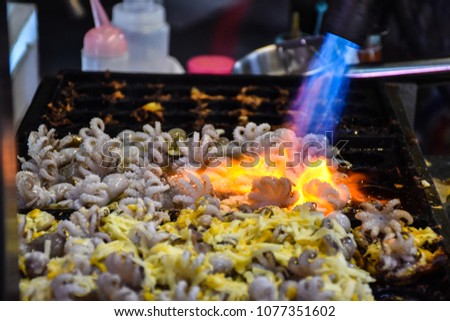 Cooking famous japanese snack takoyaki - fried octopus balls