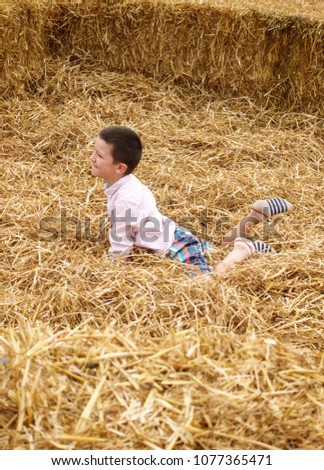 Boy lying on haystack