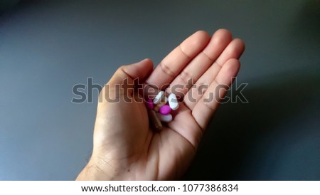 Pills and capsule put on man palms isolated with gray background. Selective focus and copy space