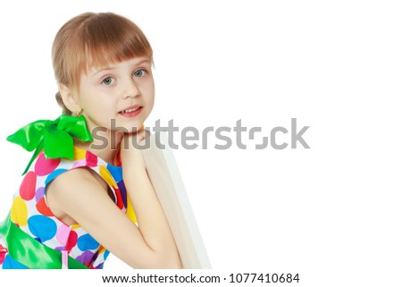 A beautiful Caucasian little blonde girl with long pigtails, in which large colored bows are braided, and a short bangs on her head. In a short summer dress.Looks because of the white obstacle.
