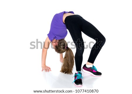 A little girl gymnast performs a bridge. The concept of childhood, sport, healthy lifestyle. Isolated on white background.