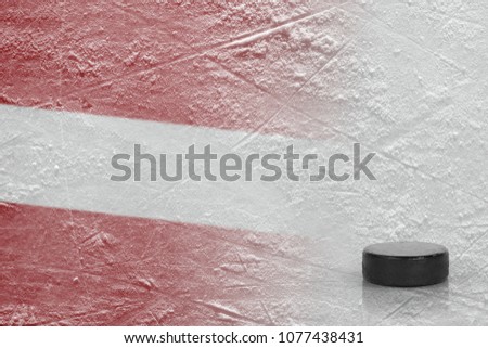 Hockey puck and the image of the Latvian flag on the ice. Concept, hockey