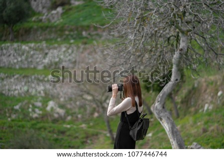 Young asian girl taking picture of the beautiful scenery while hiking along the mountain trail located at Positano, Italy.
