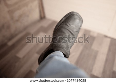 Old leather shoes on the leg of a man in a vintage style