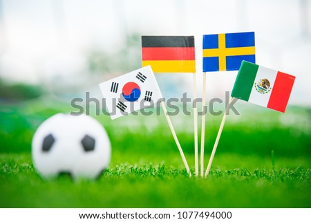 Group F and football ball on green grass. National Flags of Germany, Mexico, Sweden, Korea Republic, South Korea Royalty-Free Stock Photo #1077494000