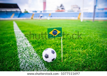 Brazil national Flag and football ball on green grass. Fans, support photo, edit space. 