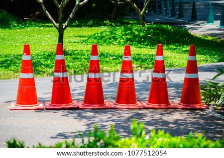 A row of orange Traffic cone on a garden street.