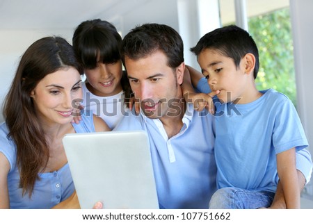 Parents and children using electronic tablet at home