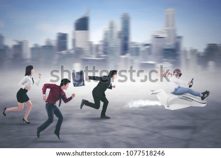 Picture of little businessman driving a plane while competing with his rivals. Shot with modern city background