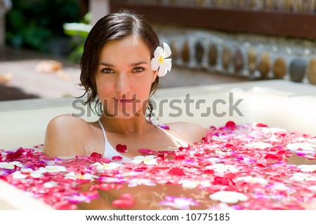 A young woman in a bath with petals and flowers Royalty-Free Stock Photo #10775185