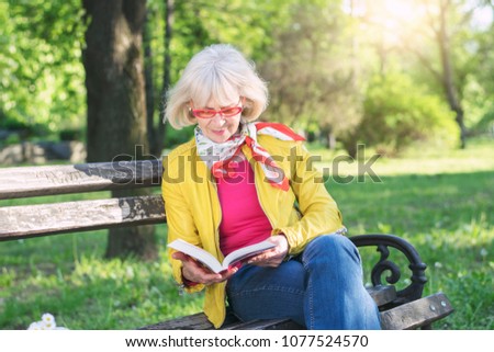 Senior woman reading a book outdoors