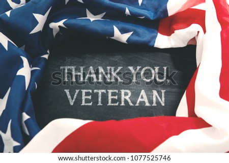 Picture of a fabric of American flag shaped a frame with text of thank you, veteran on the chalkboard