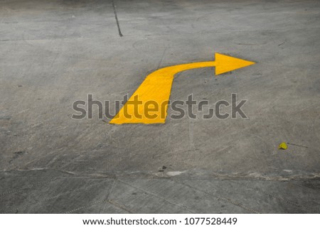 The yellow arrow symbol for a right turn, which is on the ground