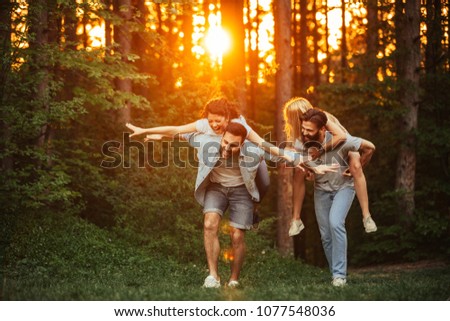 Two couples having fun in the woods.