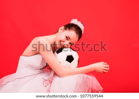 Girl in wedding ball gown with soccer ball.